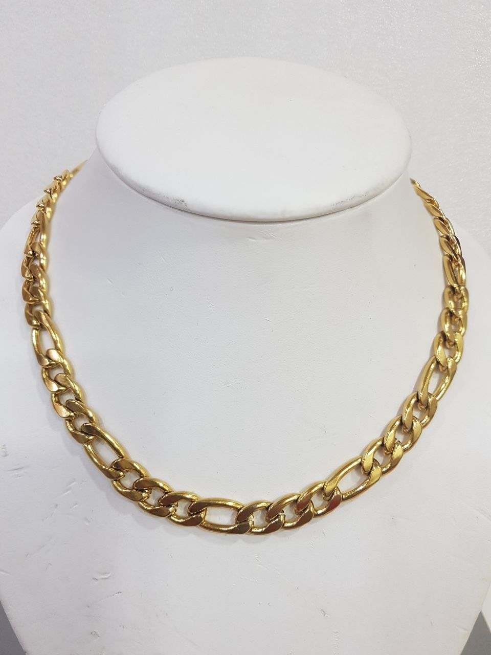 Cadena de acero dorada para hombre con diseño elegante y resistente en exhibidor blanco