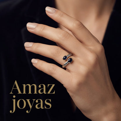 Anillo elegante de acero y oro con detalles de piedras preciosas en tonos azul y rojo.